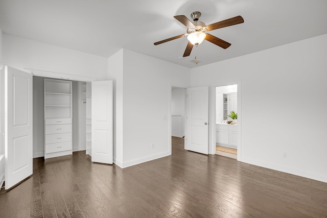 unfurnished bedroom featuring connected bathroom, a closet, ceiling fan, and dark wood-type flooring