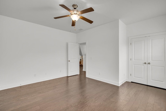 unfurnished room with dark hardwood / wood-style flooring and ceiling fan