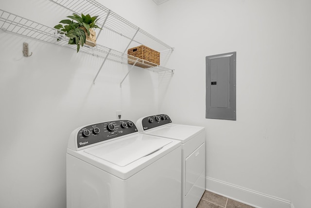 clothes washing area featuring electric panel, tile patterned flooring, and separate washer and dryer