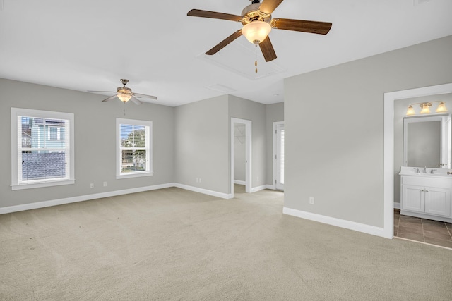 empty room featuring sink, ceiling fan, and light colored carpet