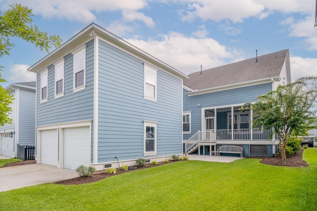 back of property featuring a garage and a lawn