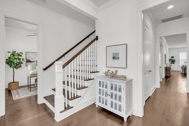 stairs featuring hardwood / wood-style floors, ornamental molding, and ceiling fan