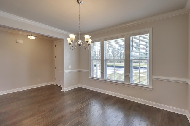 spare room with crown molding, dark wood-type flooring, and a chandelier