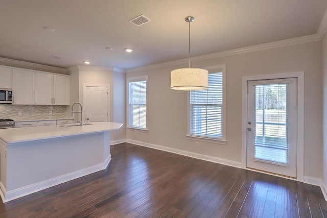 kitchen featuring pendant lighting, ornamental molding, white cabinetry, backsplash, and dark hardwood / wood-style floors