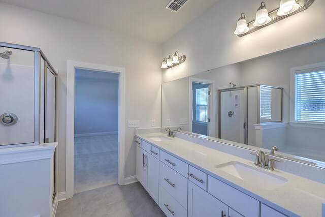 bathroom featuring double sink, tile flooring, vanity with extensive cabinet space, and walk in shower