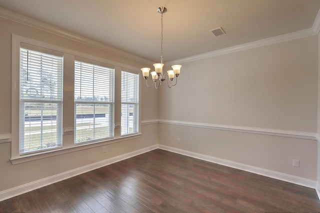 empty room featuring crown molding, dark hardwood / wood-style floors, and a notable chandelier