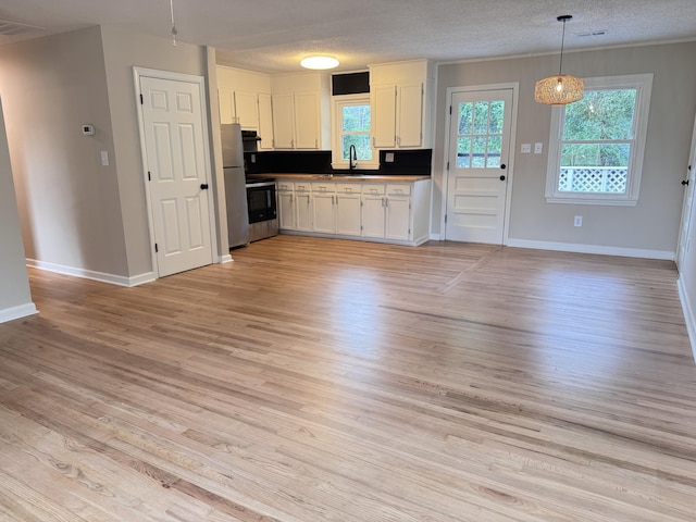105 Dandridge Rd, Walterboro, SC 29488 - kitchen with white cabinets, light wood-style floors, baseboards, and a textured ceiling