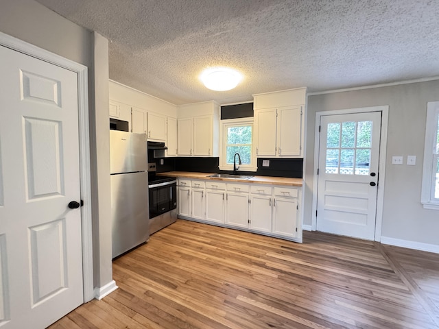 105 Dandridge Rd, Walterboro, SC 29488 - kitchen featuring appliances with stainless steel finishes, white cabinetry, light wood finished floors, a sink, and a textured ceiling