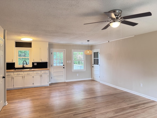 105 Dandridge Rd, Walterboro, SC 29488 - kitchen with a sink, a ceiling fan, a textured ceiling, light wood finished floors, and white cabinets