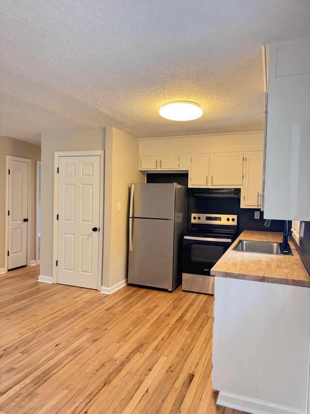 105 Dandridge Rd, Walterboro, SC 29488 - kitchen featuring stainless steel appliances, extractor fan, white cabinetry, a textured ceiling, and light wood-style flooring