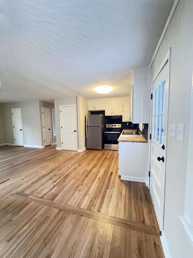 105 Dandridge Rd, Walterboro, SC 29488 - kitchen featuring freestanding refrigerator, range, light wood-style flooring, a textured ceiling, and white cabinets