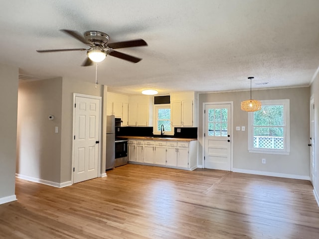 105 Dandridge Rd, Walterboro, SC 29488 - kitchen with a textured ceiling, ceiling fan, white cabinetry, a sink, and baseboards
