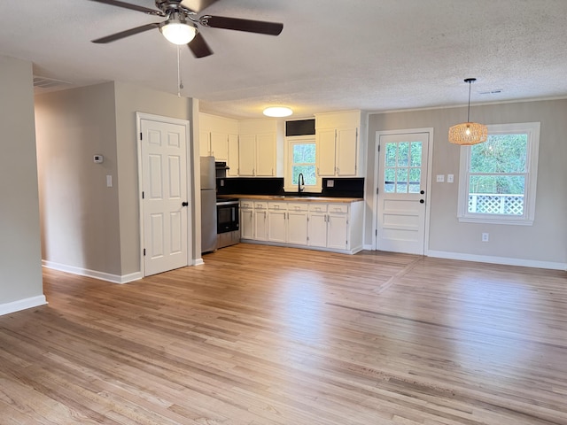 105 Dandridge Rd, Walterboro, SC 29488 - kitchen featuring a textured ceiling, white cabinets, light wood finished floors, ceiling fan, and open floor plan
