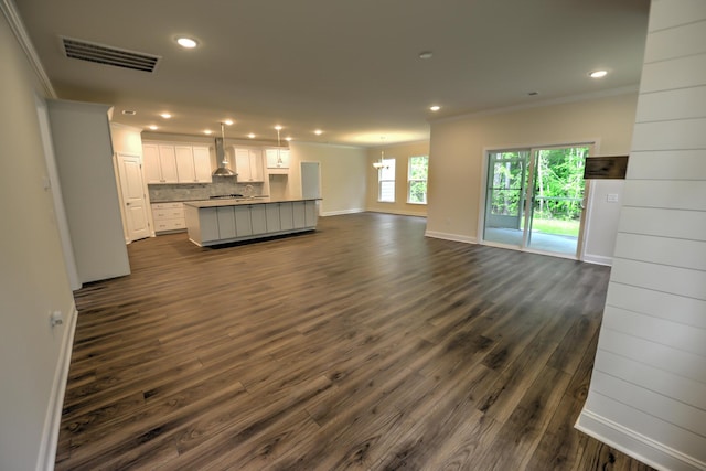 unfurnished living room featuring ornamental molding and dark hardwood / wood-style floors