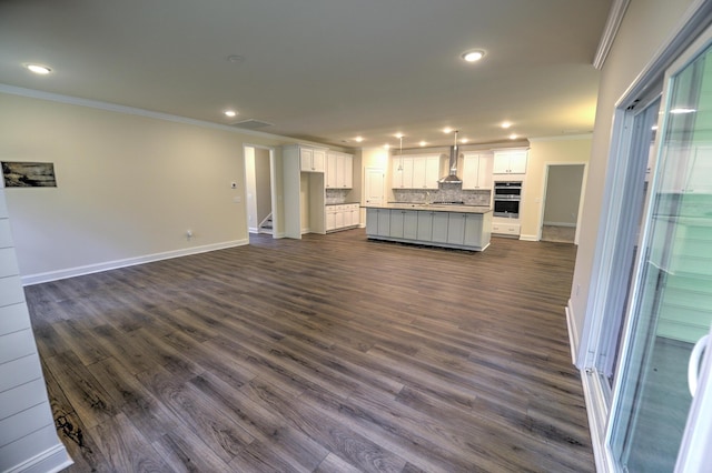 unfurnished living room featuring ornamental molding and dark hardwood / wood-style floors