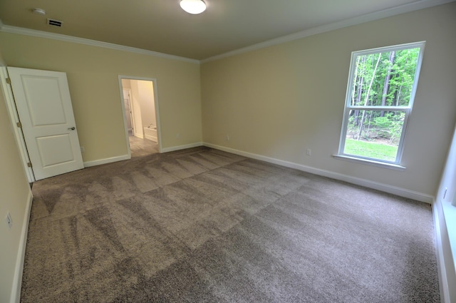 unfurnished room with ornamental molding and carpet