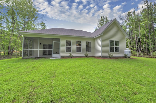 rear view of property featuring a yard and a sunroom