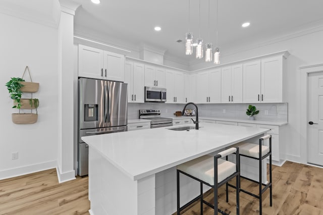 1917 Jason St, North Charleston, SC 29406 - kitchen featuring a kitchen bar, appliances with stainless steel finishes, tasteful backsplash, a sink, and light countertops