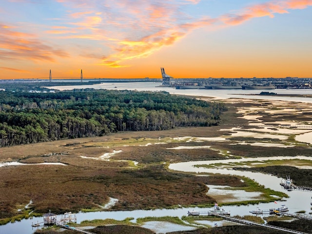 aerial view at dusk featuring a water view