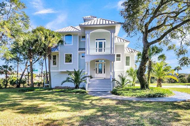 view of front of house with a balcony and a front yard