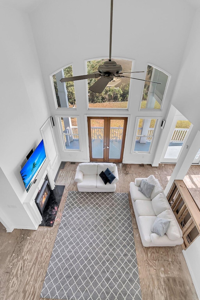 living room with ceiling fan, french doors, and a towering ceiling