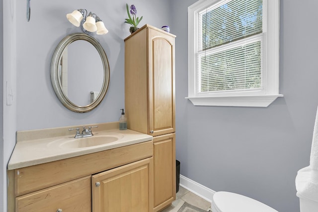 bathroom with tile patterned flooring, vanity, and toilet