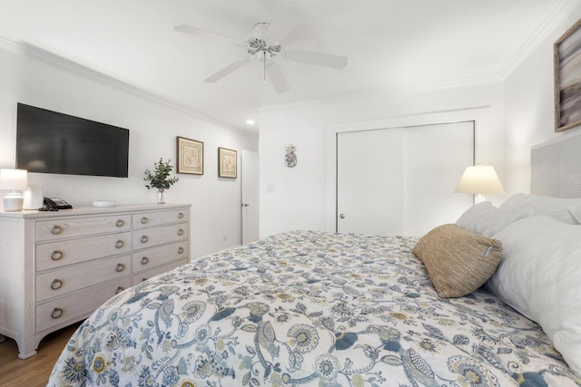 bedroom featuring ceiling fan, ornamental molding, light hardwood / wood-style floors, and a closet