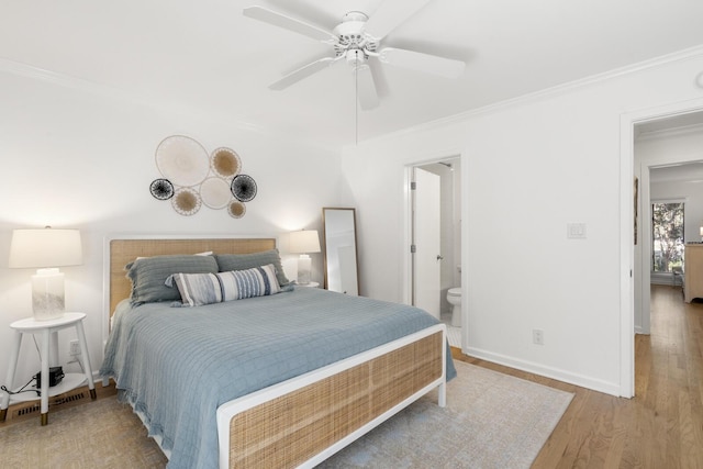 bedroom featuring crown molding, light hardwood / wood-style flooring, ceiling fan, and ensuite bathroom