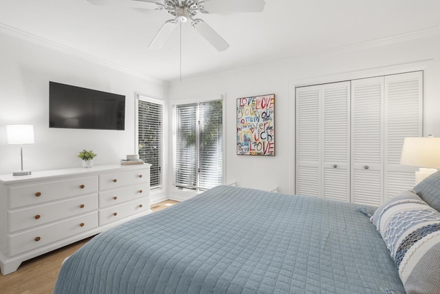 bedroom with hardwood / wood-style floors, ornamental molding, a closet, and ceiling fan