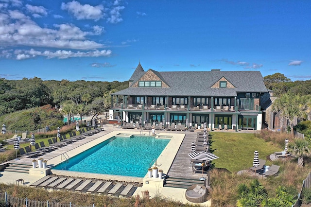 rear view of property featuring a community pool and a patio