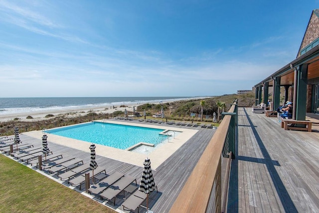 view of swimming pool featuring a water view and a view of the beach