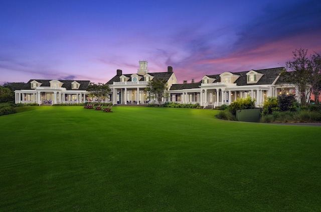 cape cod home with a lawn