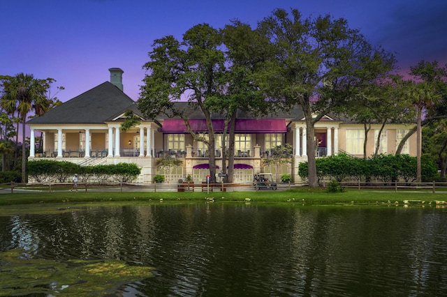 back house at dusk with a water view