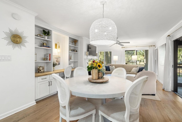 dining space featuring ornamental molding and light hardwood / wood-style floors