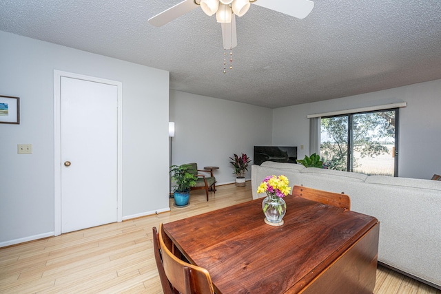 dining room with a textured ceiling, light wood finished floors, and a ceiling fan