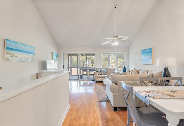 living room featuring high vaulted ceiling and light hardwood / wood-style floors