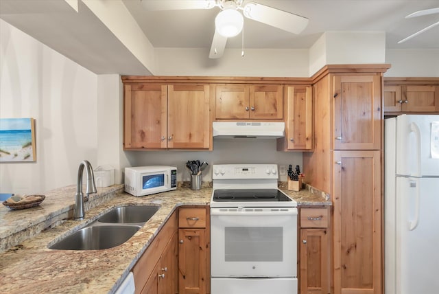 kitchen with light stone countertops, sink, white appliances, and ceiling fan