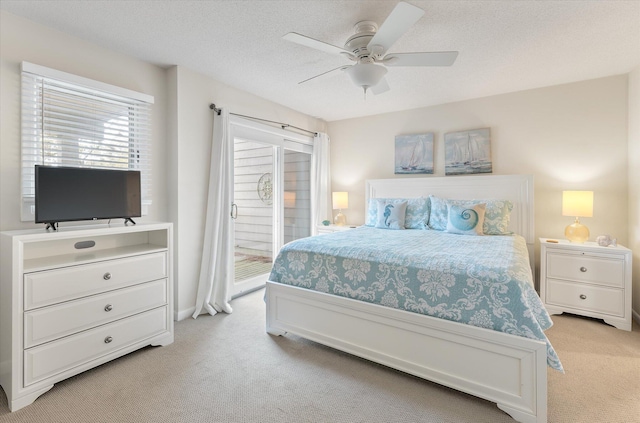 carpeted bedroom with a textured ceiling, ceiling fan, and access to exterior