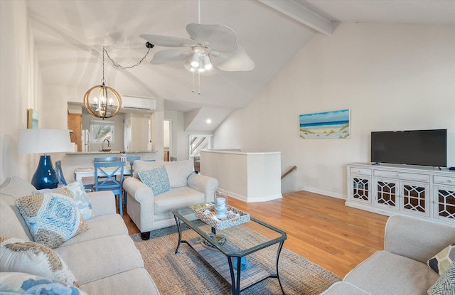 living room featuring lofted ceiling with beams, ceiling fan with notable chandelier, and wood-type flooring