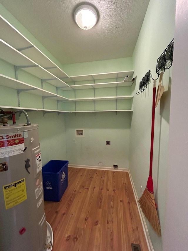 236 Chamblee Rd, Walterboro, SC 29488 - washroom featuring water heater, hookup for an electric dryer, a textured ceiling, wood finished floors, and washer hookup