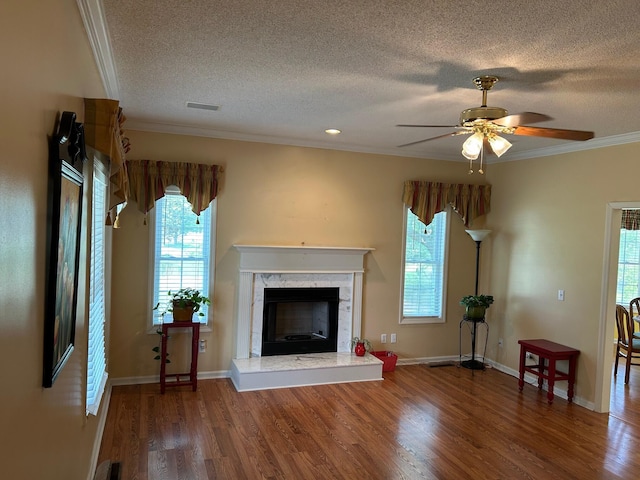 236 Chamblee Rd, Walterboro, SC 29488 - unfurnished living room with a textured ceiling, ornamental molding, wood finished floors, a premium fireplace, and healthy amount of natural light