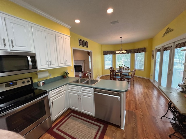 236 Chamblee Rd, Walterboro, SC 29488 - kitchen with appliances with stainless steel finishes, a sink, a peninsula, white cabinets, and wood finished floors