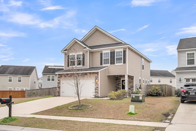 view of front of property featuring a front yard, fence, driveway, and an attached garage