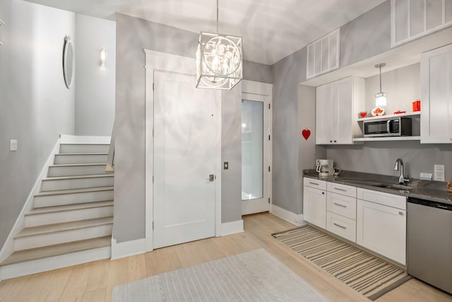 2213 Rolling Dune Rd, Seabrook Island, SC 29455 - kitchen with appliances with stainless steel finishes, light wood-style flooring, a sink, a chandelier, and baseboards