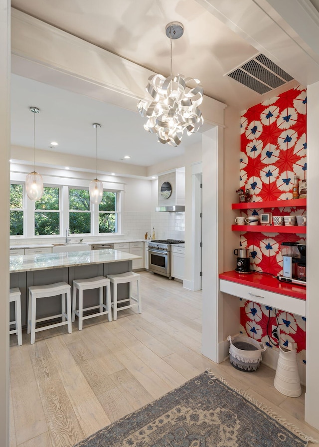 2213 Rolling Dune Rd, Seabrook Island, SC 29455 - kitchen featuring stainless steel range, a sink, backsplash, light wood-style flooring, and a chandelier