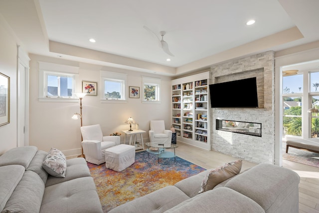 2213 Rolling Dune Rd, Seabrook Island, SC 29455 - living area featuring wood finished floors, a tray ceiling, a stone fireplace, and recessed lighting
