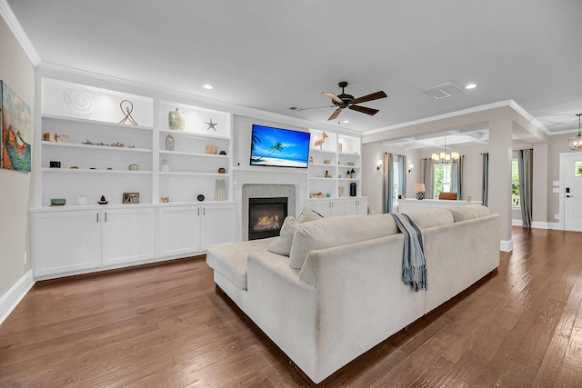 5725 Caviar Ct, Johns Island, SC 29455 - living room with crown molding, a chandelier, a glass covered fireplace, ceiling fan, and wood-type flooring