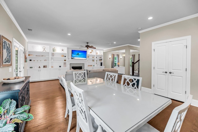 5725 Caviar Ct, Johns Island, SC 29455 - dining area with dark wood-style floors, a ceiling fan, a fireplace, crown molding, and recessed lighting