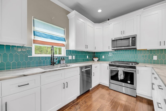 5725 Caviar Ct, Johns Island, SC 29455 - kitchen with stainless steel appliances, a sink, white cabinetry, wood finished floors, and light stone counters