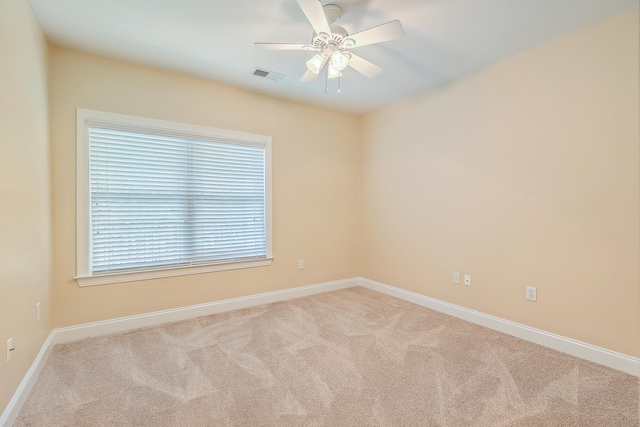 spare room featuring ceiling fan and light carpet